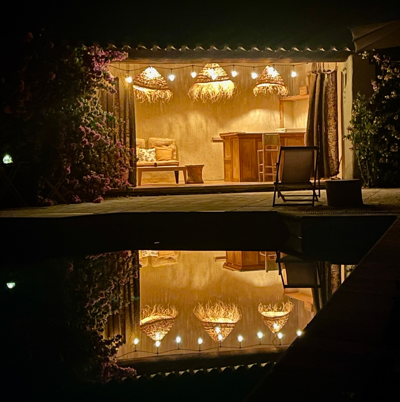Pool mit beleuchtetem Poolhaus in der Nacht